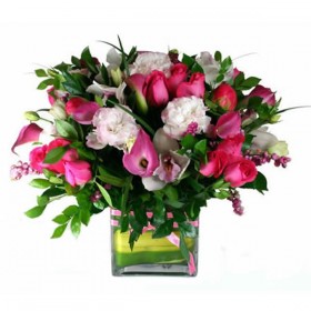 Pink and White flowers arranged in a clear cubed vase.